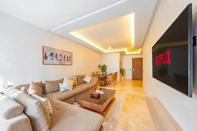 a living room with a couch and a tv at Appartement au coeur de Marrakech à côté de la gare avec piscine in Marrakech