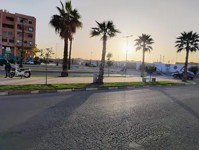 an empty street with palm trees in a city at Home sweet home in Marrakech in Marrakech