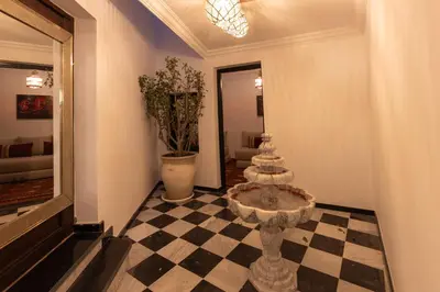 a hallway with a table and a checkerboard floor at Riad Zehra in Marrakech