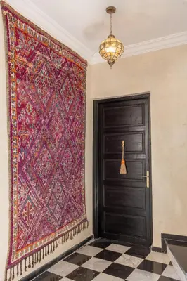 a large rug hanging on a wall next to a door at Riad Zehra in Marrakech