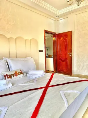 a bedroom with a large bed with a red door at Marakech home in Marrakech