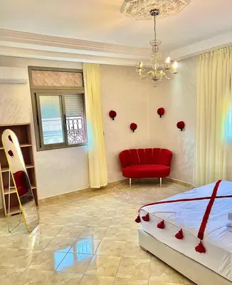 a bedroom with a red bed and a red chair at Marakech home in Marrakech