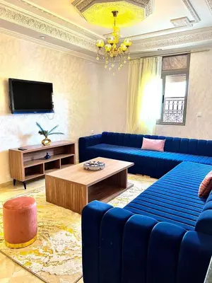 a living room with blue couches and a tv at Marakech home in Marrakech