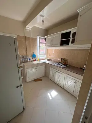 a kitchen with white cabinets and a window at Cozy appartement en plein coeur de Guéliz in Marrakech