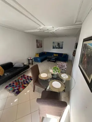 a living room with a table and a couch at Cozy appartement en plein coeur de Guéliz in Marrakech
