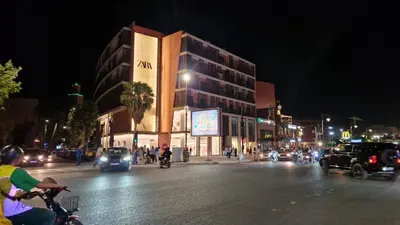 a busy city street at night with cars and people at APPART GUELIZ PLAZA MARRAKECh in Marrakech