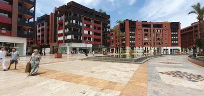 a woman standing in a plaza in a city at APPART GUELIZ PLAZA MARRAKECh in Marrakech