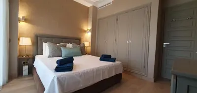 a bedroom with a large bed with blue pillows on it at APPART GUELIZ PLAZA MARRAKECh in Marrakech