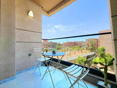 a balcony with a table and chairs and a view at Appt de Luxe avec Terrasse,PiscinePartagée & wifi in Marrakech