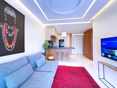 a living room with a blue couch and a red rug at Appt de Luxe avec Terrasse,PiscinePartagée & wifi in Marrakech
