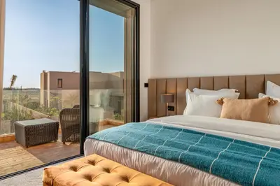 a bedroom with a large bed and a balcony at Sumptuous Villa, Heated Pool, 15minutes to City Center, Daily Housekeeping, Private Cook and Chauffeur, Games in Marrakech