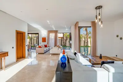 a living room with a couch and a table at Sumptuous Villa, Heated Pool, 15minutes to City Center, Daily Housekeeping, Private Cook and Chauffeur, Games in Marrakech