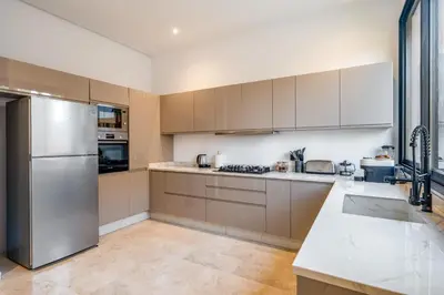a kitchen with white cabinets and a stainless steel refrigerator at Sumptuous Villa, Heated Pool, 15minutes to City Center, Daily Housekeeping, Private Cook and Chauffeur, Games in Marrakech