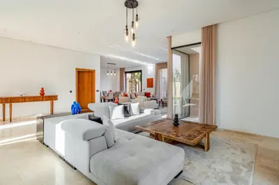 a living room with white couches and a table at Sumptuous Villa, Heated Pool, 15minutes to City Center, Daily Housekeeping, Private Cook and Chauffeur, Games in Marrakech