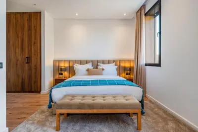 a bedroom with a large bed with a bench in it at Sumptuous Villa, Heated Pool, 15minutes to City Center, Daily Housekeeping, Private Cook and Chauffeur, Games in Marrakech