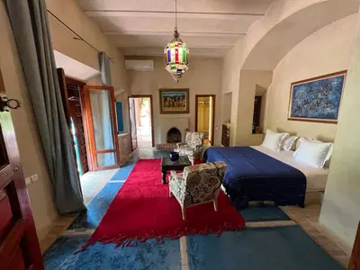 a bedroom with a bed and a red rug at Villa Grenade in Marrakech