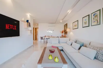 a living room with a white couch and a table at 3 Bedroom Apartment with Pool View Prestigia in Marrakech