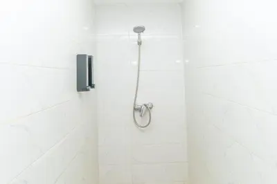 a shower in a white tiled bathroom at Studio calme au cœur de Marrakech Guiliz, proche Victor Hugo in Marrakech