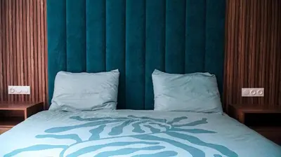 a bed with a green headboard and two pillows at Appartement de luxe au cœur du quartier majorelle in Marrakech