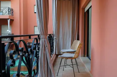 a balcony with a chair and a table at Appartement de luxe au cœur du quartier majorelle in Marrakech