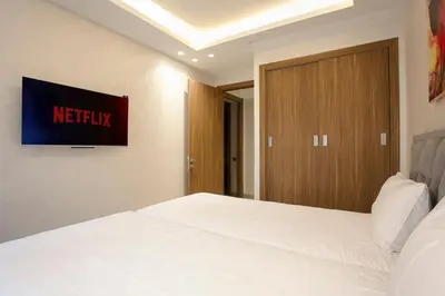 a bedroom with a white bed and a wooden door at The Modern Luxury - Marrakech in Marrakech