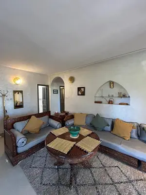 a living room with a couch and a table at Maison à la Palmeraie avec piscine et parking à Marrakech in Marrakech