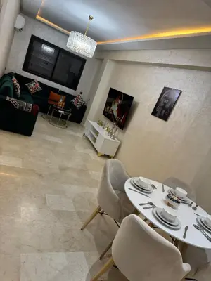 a living room with a white table and chairs at Apartment piscine gueliz hivernage ctm train aeroport supratour in Marrakech