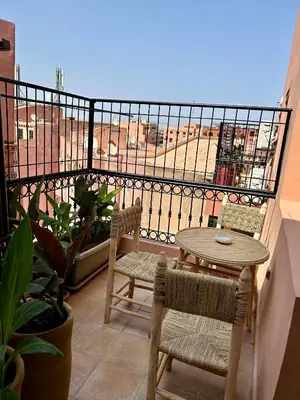 a balcony with a table and chairs on a balcony at Appartement marrakech in Marrakech