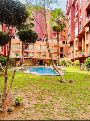 a large apartment building with a swimming pool in a park at Appartement marrakech in Marrakech