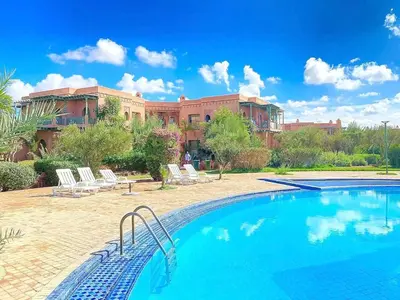 a swimming pool in front of a building at Appartement standing piscine la palmeraie in Marrakech