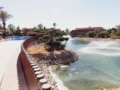 a swimming pool with a fountain in a resort at Appartement standing piscine la palmeraie in Marrakech