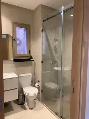 a bathroom with a toilet and a glass shower at Mon paradis Golf & Piscine in Marrakech