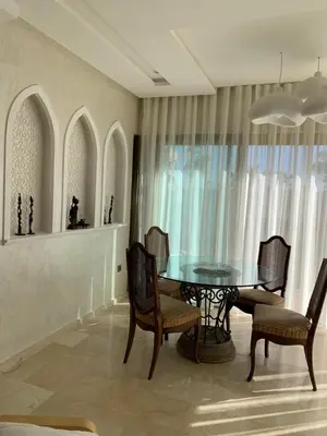 a dining room with a glass table and chairs at Mon paradis Golf & Piscine in Marrakech