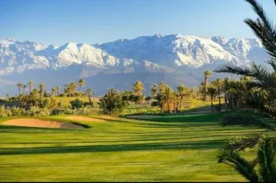a view of a golf course with mountains in the background at Mon paradis Golf & Piscine in Marrakech