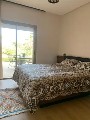 a bedroom with a bed and a sliding glass door at Mon paradis Golf & Piscine in Marrakech