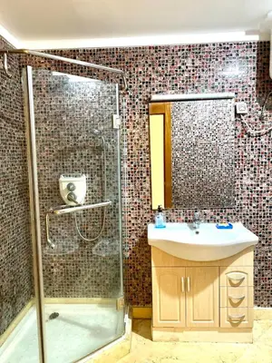 a bathroom with a shower and a sink at Magnifique F3 au Riad Arfoud avec piscine in Marrakech