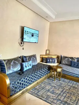 a living room with a couch and a table at Magnifique F3 au Riad Arfoud avec piscine in Marrakech