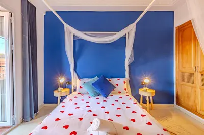 a bedroom with a bed with a blue wall at Boho chic retreat in Marrakech