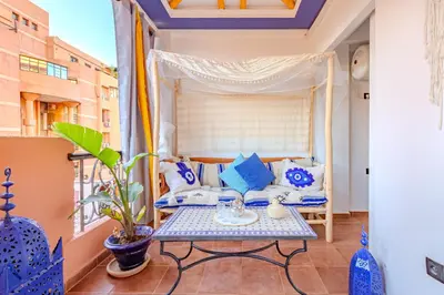 a balcony with a couch and a table at Boho chic retreat in Marrakech