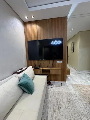 a living room with a white couch and a flat screen tv at Résidence Soulaymane اقامة سليمان in Marrakech