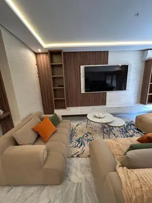 a living room with a couch and a tv at Appartement spacieux 1 chambre avec piscine Palmeraie Gates in Marrakech