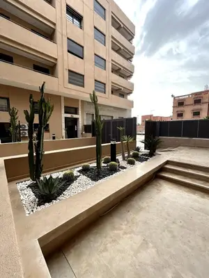 a courtyard with cacti and plants in front of a building at Appartement spacieux 1 chambre avec piscine Palmeraie Gates in Marrakech