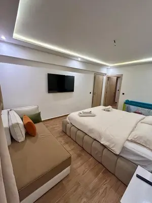 a bedroom with a large bed and a flat screen tv at Appartement spacieux 1 chambre avec piscine Palmeraie Gates in Marrakech