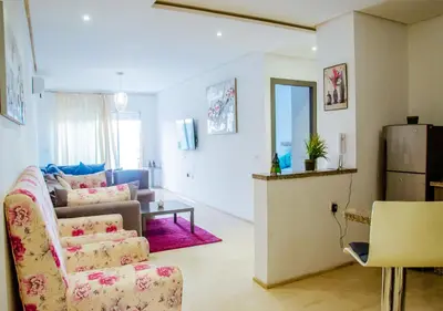 a living room with a couch and a refrigerator at Appartement Chic et Lumineux, Proche Gare in Marrakech