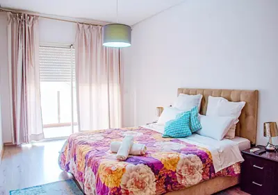 a bedroom with a large bed with a colorful blanket at Appartement Chic et Lumineux, Proche Gare in Marrakech