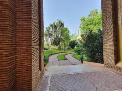 an outside view of a brick building with a walkway at Apartment with pool and garden in Marrakech