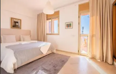 a bedroom with a bed and a large window at Lux apartment With a Sunset View in Marrakech