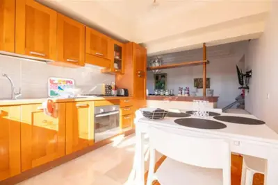 a kitchen with wooden cabinets and a white island at Lux apartment With a Sunset View in Marrakech