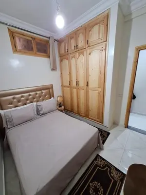 a bedroom with a large bed and wooden cabinets at Apartment in Marrakech , Near Jamaa El Fna in Marrakech