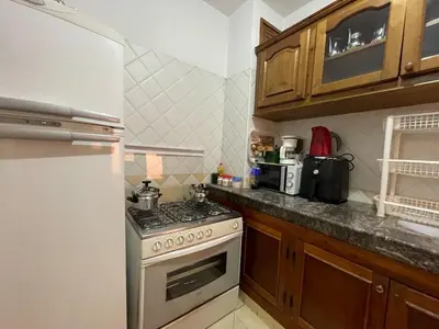 a kitchen with a stove and a white refrigerator at Beautiful family apartment with parking in Marrakech
